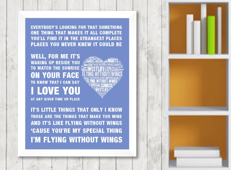 May include: A framed print with a white border, featuring lyrics in white text on a blue background. The text includes song lyrics and a heart-shaped design with the words "Flying Without Wings" and "Westlife."