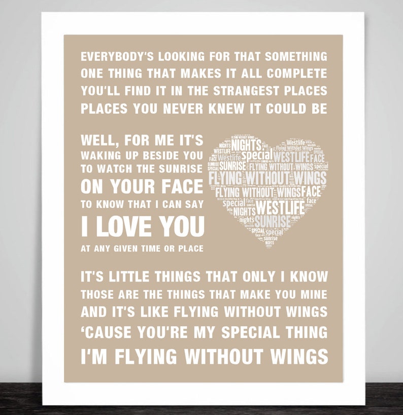 May include: A framed print with a beige background features white text. The text includes song lyrics and the words "I Love You" in a bold font. A heart-shaped design contains the words "Westlife" and "Flying Without Wings".