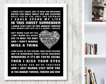 May include: Black and white framed print featuring song lyrics from "I Don't Want to Miss a Thing" by Aerosmith. The lyrics are arranged in a heart shape. The print is displayed on a white wall.