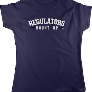 May include: A navy blue t-shirt with the text "REGULATORS -MOUNT UP-" in white, arched across the chest. The shirt is a crew neck style and appears to be made of a soft material.