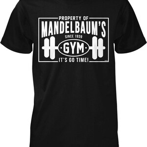 May include: Black t-shirt with a white graphic that reads "PROPERTY OF MANDELBAUM'S GYM SINCE 1939. IT'S GO TIME!" The graphic includes a barbell design.
