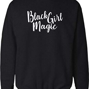 May include: Black crew neck sweatshirt with the text "Black Girl Magic" in white script. The sweatshirt is black and has a ribbed hem and cuffs.