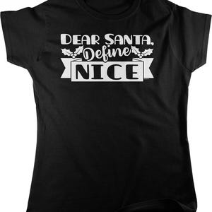May include: A black short-sleeved t-shirt featuring white text that reads "DEAR SANTA, Define NICE" in a bold font. The design includes a graphic of holly leaves and berries above the word "Define" and a banner behind the word "NICE".