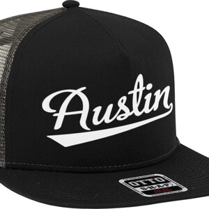 May include: Black and gray trucker hat with a white cursive script that says "Austin".