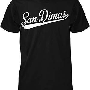 May include: Black t-shirt with the white text "San Dimas" in a script font, with a white angled stripe underneath. The shirt has a crew neck and short sleeves. The design is centered on the chest.
