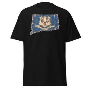 Puede incluir: Una camiseta negra de manga corta con un gráfico desgastado del estado de Connecticut en azul, que contiene el sello estatal con tres vides y una pancarta con el texto en latín Qui Transtulit Sustinet centrado en el pecho.