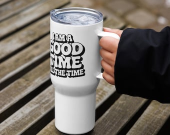 May include: A white stainless steel travel tumbler with a handle and a clear plastic lid. The tumbler features bold black text that reads I AM A GOOD TIME ALL THE TIME in a stacked, retro-inspired font on the front surface of the cup.