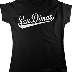 May include: Black t-shirt with the white text "San Dimas" in a script font with a white underline. The shirt has short sleeves and a crew neck.