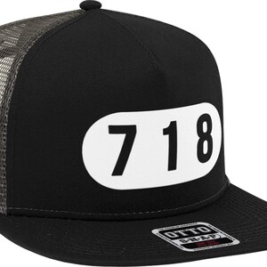 May include: Black trucker hat with a white oval patch that says "718" on it. The hat has a mesh back and a black bill.
