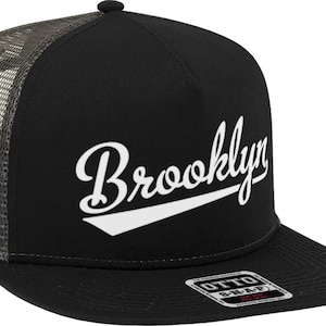 May include: Black and gray trucker hat with a white embroidered "Brooklyn" logo. The hat has a mesh back and a flat brim.