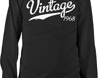 Puede incluir: Una camiseta negra de manga larga con el texto blanco Vintage 1968 impreso en el pecho. La palabra Vintage está escrita en una fuente cursiva grande, con el año 1968 posicionado debajo en una tipografía clara y sin remates.