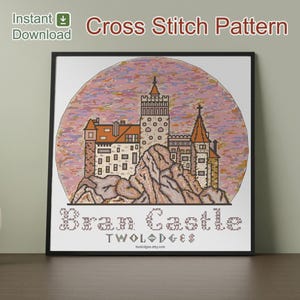 Könnte beinhalten: Kreuzstichmuster von Schloss Bran, das eine detaillierte Darstellung des Schlosses auf einer felsigen Landschaft vor einem rosa-orangenen kreisförmigen Hintergrund zeigt. Die Worte "Bran Castle" und "Two Lodges" sind darunter gestickt. Die Worte "Sofort-Download" befinden sich oben links.