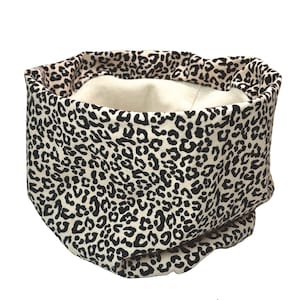 Könnte beinhalten: Ein beige-schwarzer Leopardenmuster-Halswärmer aus Stoff. Der Halswärmer ist aus weichem, dehnbarem Stoff gefertigt und perfekt, um sich im Winter warm zu halten.