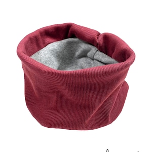 May include: A burgundy ribbed knit neck warmer with a grey fleece lining.