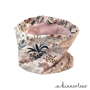 Könnte beinhalten: Ein weißer Halsschmuck mit einem Blumenmuster in Rosa-, Braun- und Grüntönen. Der Halsschmuck ist mit einem weichen rosa Stoff gefüttert.