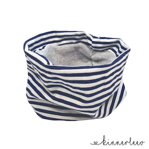 Könnte beinhalten: Ein marineblau-weiß gestreifter Halstuch. Das Halstuch ist ein Stoffschlauch mit grauem Innenfutter. Der Text "kinnerleev" ist in Schreibschrift unten rechts geschrieben.