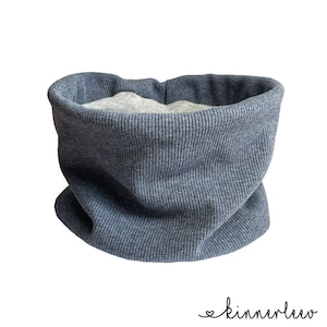 Könnte beinhalten: Ein blauer gerippter Strick-Halswärmer mit grauem Fleece-Futter.