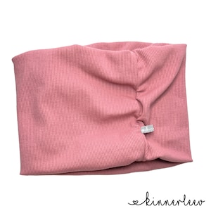 May include: A pink ribbed fabric headband with a small white label that says "kinnerlee" on it.