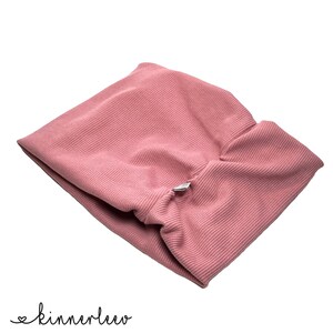May include: A pink ribbed fabric headband with a small silver button.
