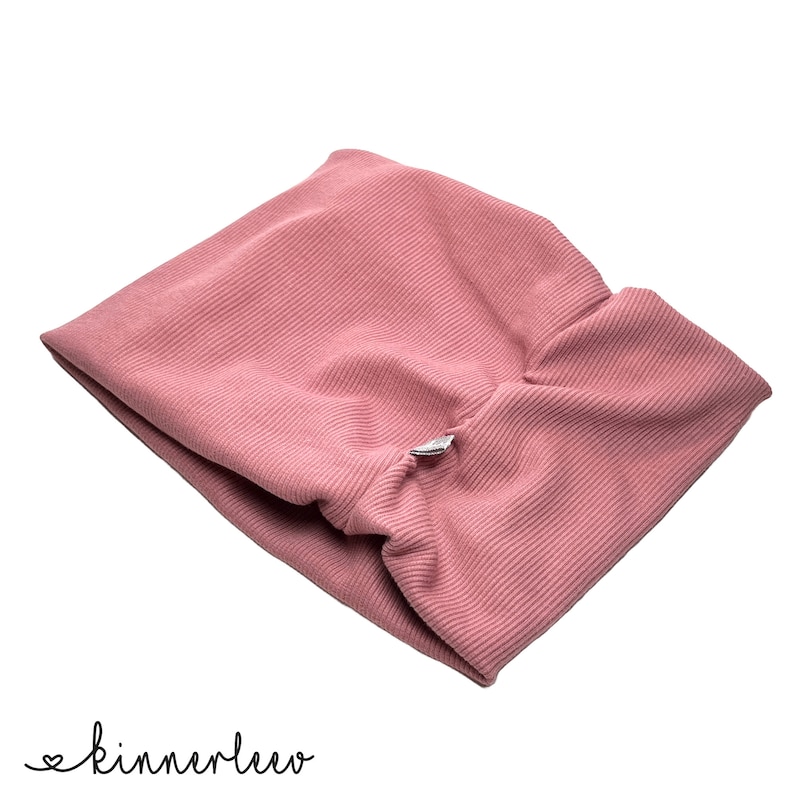 May include: A pink ribbed fabric headband with a small silver button.