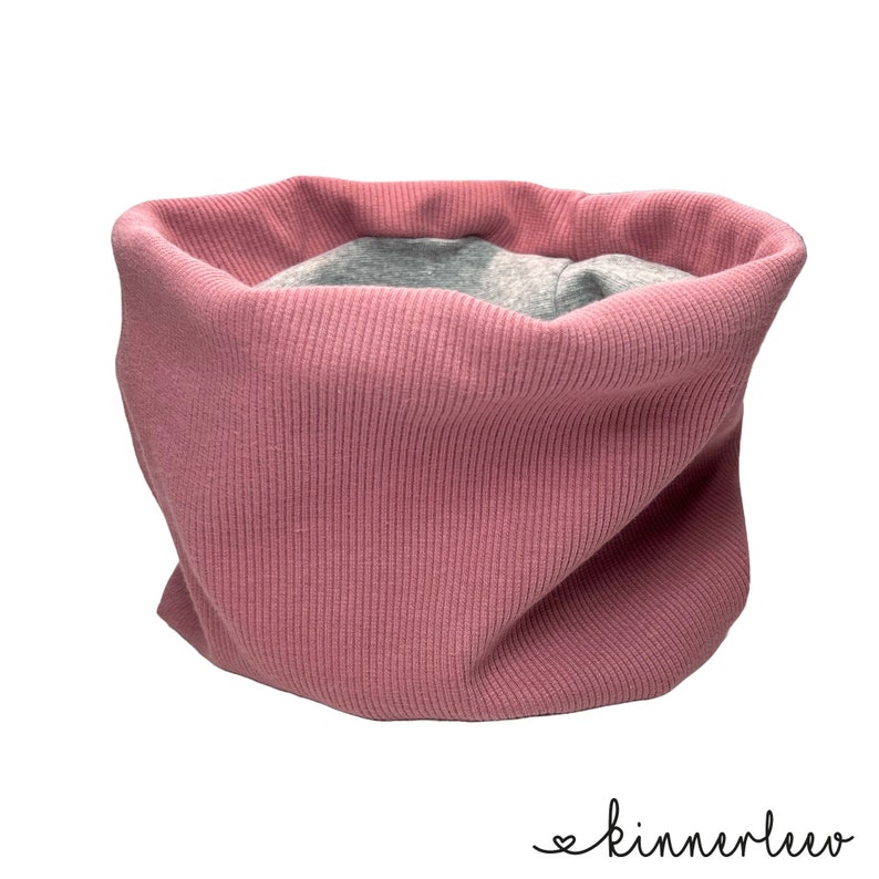 May include: A pink ribbed knit neck warmer with a grey lining.