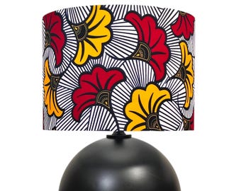 May include: A black spherical table lamp with a patterned lampshade. The lampshade features a repeating floral design in red and yellow against a white background with black lines. The lamp base is a solid black sphere.