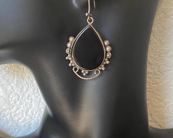 May include: Black teardrop-shaped gemstone earrings with silver bead accents and a silver wire design.