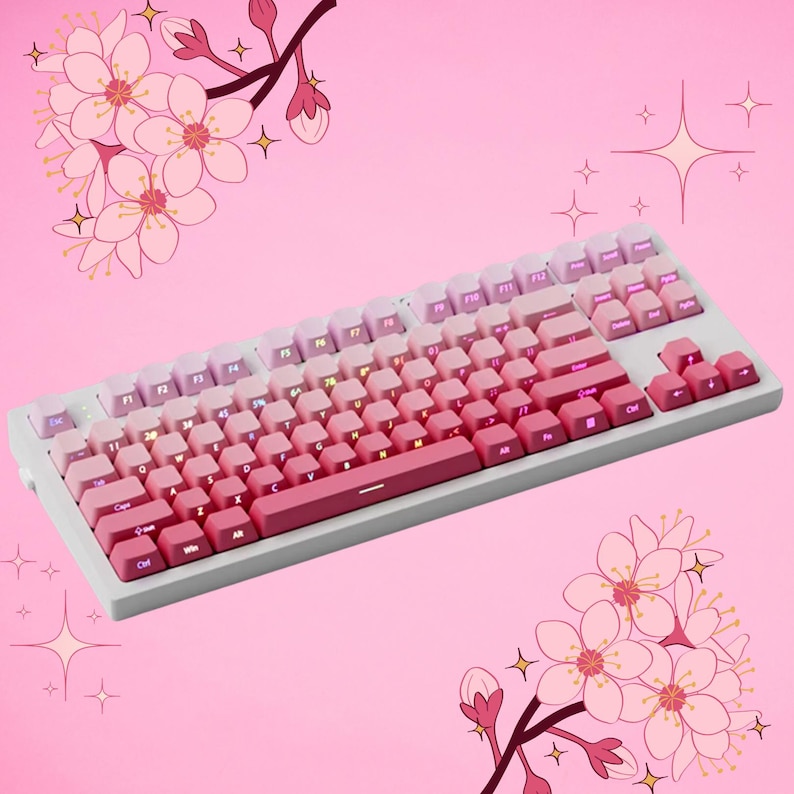K&ouml;nnte beinhalten: Eine wei&szlig;e mechanische Tastatur mit rosa und lila Tastenkappen in einem Farbverlauf. Die Tastatur hat einen hellgrauen Rahmen und befindet sich vor einem rosa Hintergrund mit Kirschbl&uuml;ten-Illustrationen.