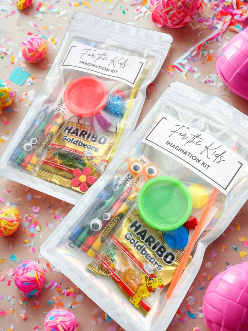 May include: Two clear plastic bags labeled "For the Kids IMAGINATION KIT" filled with crayons, play dough, googly eyes, and Haribo Goldbears candy. The bags are surrounded by colorful confetti and decorative balls.