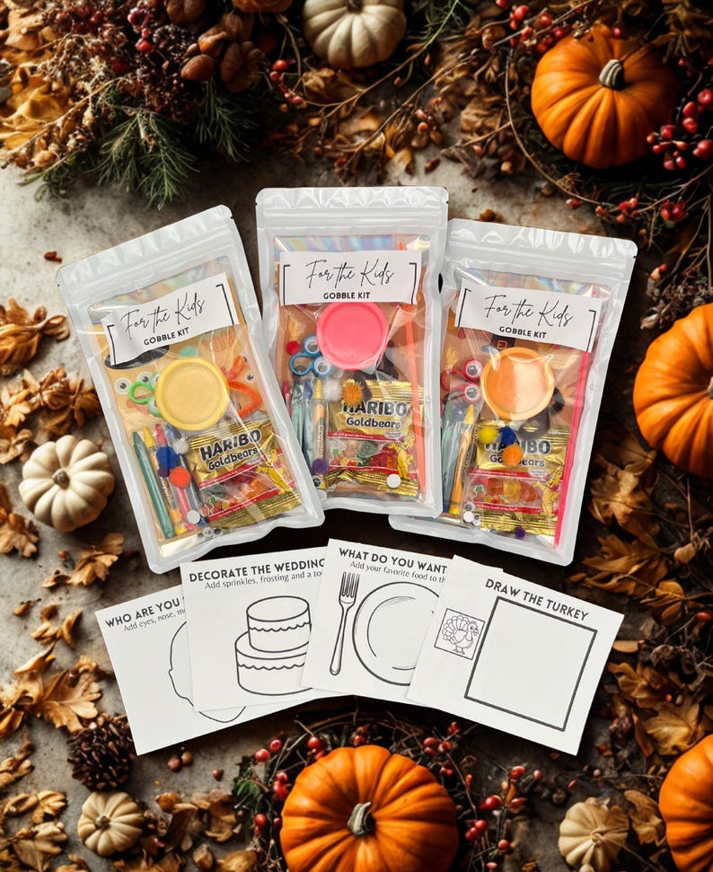 May include: Three clear plastic bags labeled "For the Kids" and "Gobble Kit" filled with craft supplies and candy. The bags are surrounded by pumpkins, gourds, and fall foliage. Coloring pages are also visible.