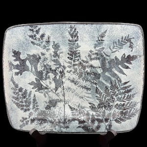 May include: A rectangular glass platter featuring a detailed black botanical fern and leaf print against a textured, speckled white and light gray background. The word Walter is printed in small black letters in the bottom left corner.