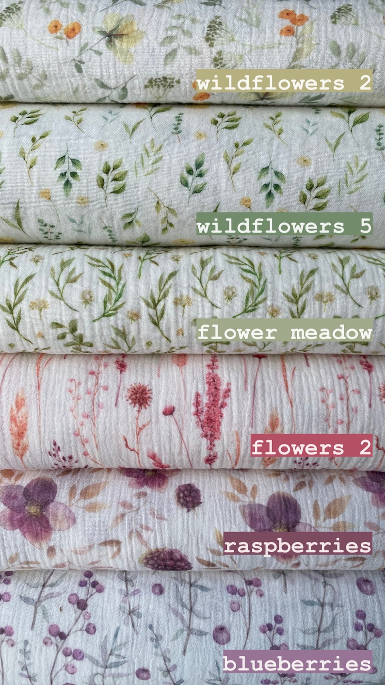 May include: Stack of five white fabric squares with different floral patterns. The patterns include wildflowers, a flower meadow, flowers, raspberries, and blueberries. The fabric squares are labeled with the names of the patterns.