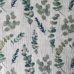 May include: White fabric with a repeating pattern of green and blue watercolor eucalyptus leaves.