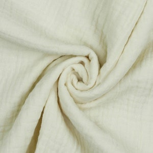 May include: A close-up of a soft, white fabric with a crinkled texture. The fabric is folded and draped, creating a smooth, flowing look.