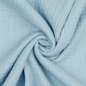 May include: A soft, light blue fabric with a crinkled texture. The fabric is folded and draped, creating a swirling pattern.