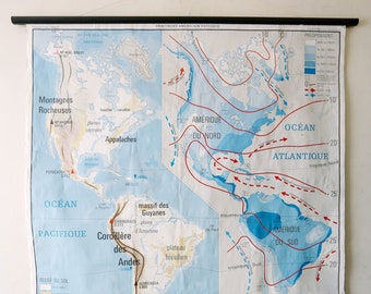 May include: A vintage educational map of North and South America, showing the physical geography of the continents. The map features blue and red lines indicating ocean currents and wind patterns, as well as labels for major geographical features like the Rocky Mountains, the Andes, and the Amazon Basin.