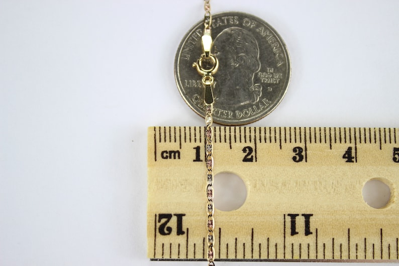 Puede incluir: Un collar de cadena de oro con cierre de langosta, medido con una regla y una moneda de 25 centavos de d&oacute;lar estadounidense. La cadena mide aproximadamente 5 cm de largo.