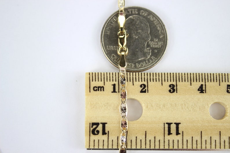 Puede incluir: Un collar de cadena de oro con un cierre, medido con una regla y una moneda de un cuarto de d&oacute;lar estadounidense. La cadena mide aproximadamente 5 cm de largo.