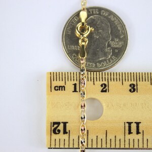 Puede incluir: Un collar de cadena de oro con un cierre de langosta, medido con una regla y una moneda de 25 centavos de d&oacute;lar estadounidense. La cadena mide aproximadamente 3,8 cm de largo.