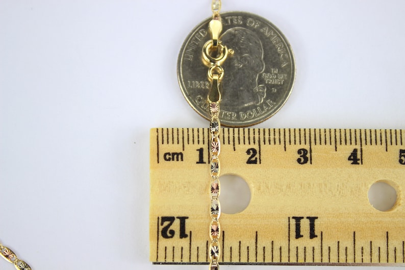 Puede incluir: Un collar de cadena de oro con un cierre de langosta, medido con una regla y una moneda de 25 centavos de d&oacute;lar estadounidense. La cadena mide aproximadamente 3,8 cm de largo.