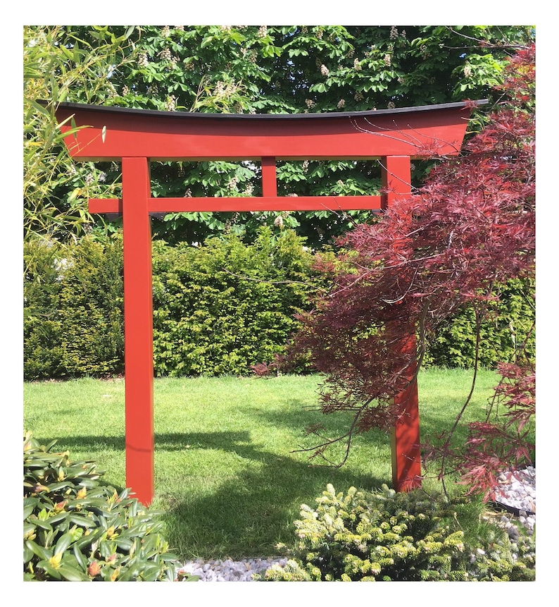 Pu&ograve; includere: Un torii in legno rosso, un tradizionale portale giapponese, si erge in un giardino. Il torii &egrave; fatto di legno e ha una parte superiore nera. Il torii &egrave; circondato da vegetazione verde e da un acero rosso.