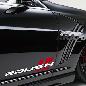Puede incluir: Un coche negro con un logotipo de Roush en el lateral. El coche tiene una llanta negra y plateada con una pinza de freno roja. El coche tiene un kit de carrocería personalizado con ventilaciones en el lateral.