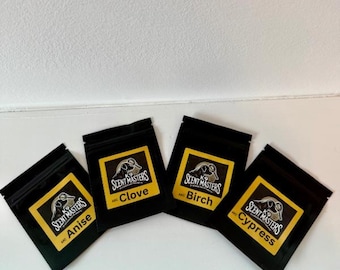 Può includere: Quattro piccole buste nere con etichette gialle. Ogni busta contiene un profumo diverso: Anice, Chiodi di garofano, Betulla e Cipresso. Le buste sono etichettate con il testo "Scent Masters".