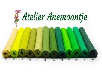 May include: A collection of 10 rolls of felt in shades of green and yellow, ranging from a pale yellow to a deep forest green. The felt rolls are labeled with numbers, including 13, 42, 43, 44, 45, 46, 47, 48, 70, and 79.