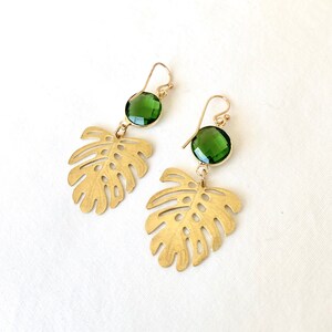 May include: Gold earrings with green gemstone accents and a cutout leaf design.