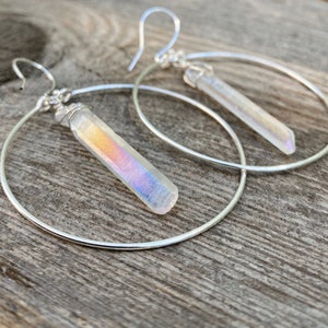 Puede incluir: Pendientes de aro de plata con colgantes de cristal iridiscente en forma de l&aacute;grima. Los pendientes son un accesorio moderno y elegante.