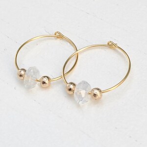 May include: Gold hoop earrings with clear crystal beads.