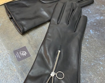May include: A pair of black leather gloves with a zipper detail on the back of the hand. The zipper has a silver ring pull.