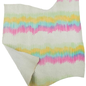 Könnte beinhalten: Ein Stück weißes Leder mit einem farbenfrohen Batikmuster. Das Muster zeigt horizontale Streifen in Rosa, Gelb, Grün und Blau. Das Leder hat ein strukturiertes, schlangenartiges Muster.