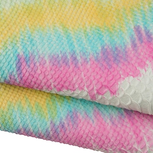 Könnte beinhalten: Nahaufnahme eines Stücks weißen Leders mit einem farbenfrohen Batikmuster. Die Farben umfassen Gelb, Blau, Rosa und Grün. Das Leder hat ein strukturiertes, schuppiges Aussehen.